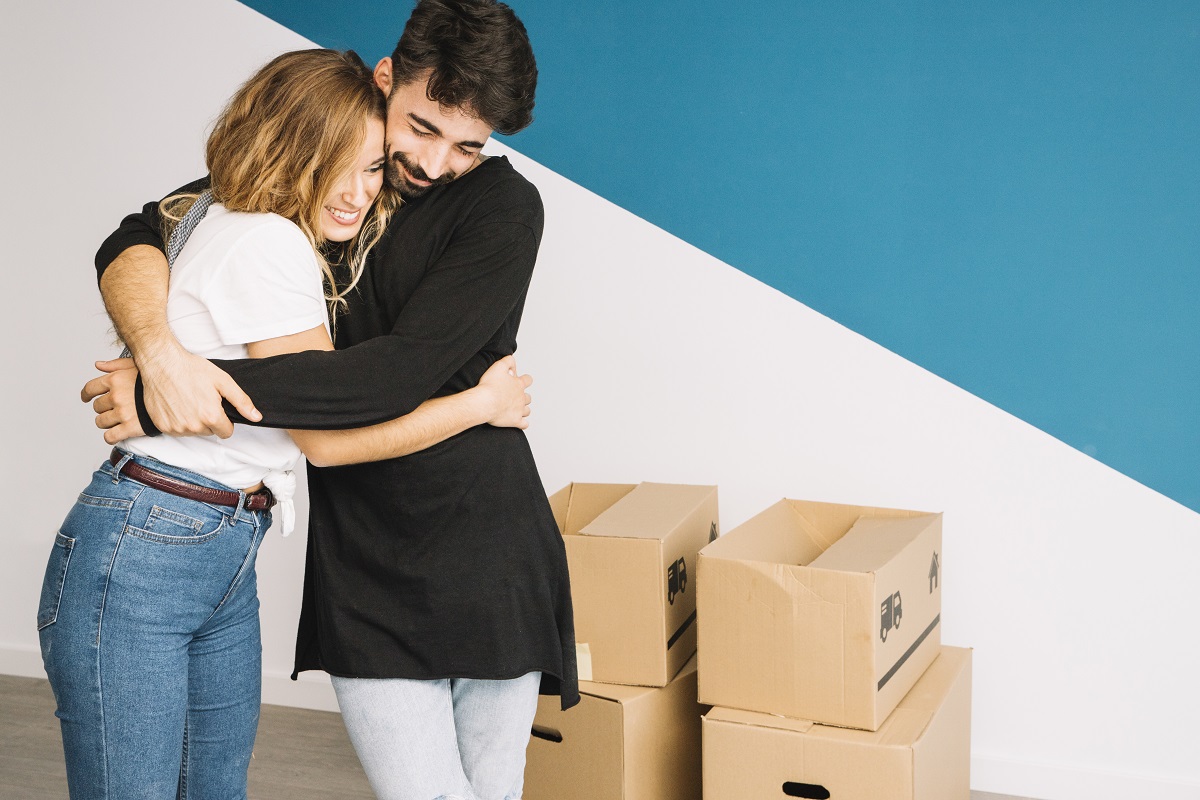 Mudança de apartamento para casa? Desafios e soluções práticas 1 Casal abraçado depois de se mudar para seu apartamento